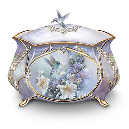 Lena Liu Hummingirds Porcelain Music Box Heirloom Porcelain® with delicate hummingbird art and iridescent colors, 22K gold, Swarovski® crystal, faux gems and inscription inside.
Measures about 4" W