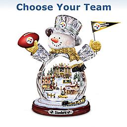 "Choose Your Team" NFL Crystal Snowman With Moving Train First-ever NFL-licensed snowman with sculpted illuminated village in his crystal body. Dressed in team colors, logos. Real moving train circles base.
Measures 11" H