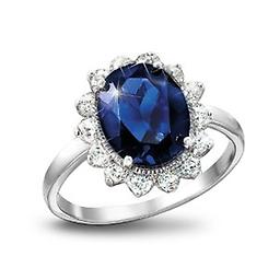 Kate Middleton's Engagement Ring Replica: Royal Inspiration Handcrafted solid sterling silver ring features a royally-sized created sapphire encircled by 14 simulated diamonds - over 5 carats in all! Gift box.
